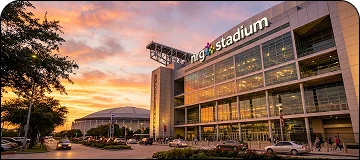 Sunset lit view of NRG stadium in close up side angle.
